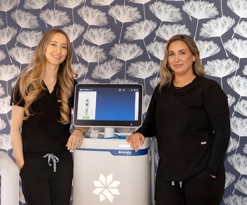 Two Thrive Med Spa team members standing beside a CoolSculpting Elite device displaying treatment information